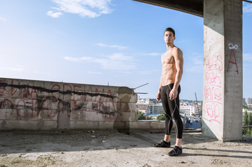 young man fit muscular model posing outdoors buildings