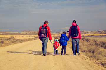 family with two kids walking on scenic road, tourism concept