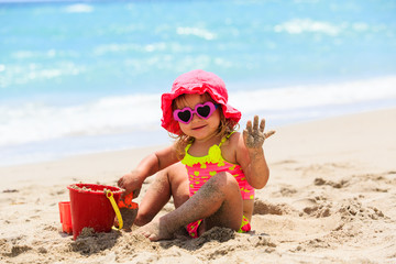 cute little girl play with sand on beach