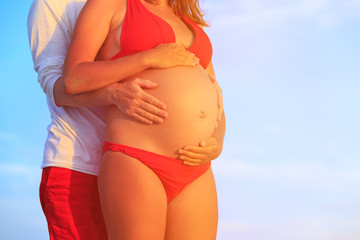Fototapeta na wymiar Happy pregnant couple at beach
