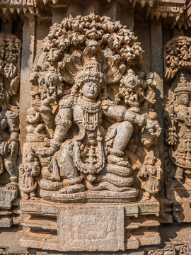 A carving of the Hindu god Vishnu sitting beneath a tree at the 13th Century temple of Somanathapur, Karnataka, South India.