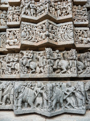 A wall covered in sculpted figures symbolizing different historical events at the 13th Century temple of Somanathapur, Karnataka, South India.