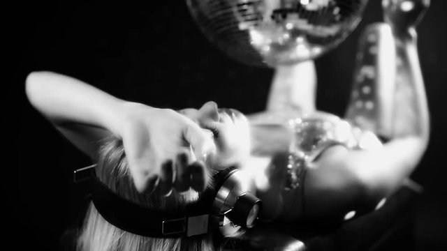 sexy girl dancing next to spinning discoball