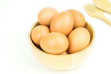 Eggs in wooden bowl  spoon and fork isolated on white background