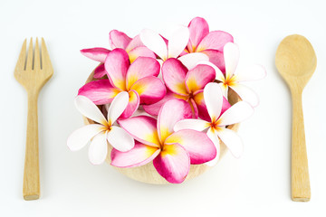 Plumeria in wooden bowl spoon and frok on white background