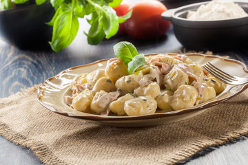 Potato gnocchi, Italian potato dumplings with cheese sauce, ham