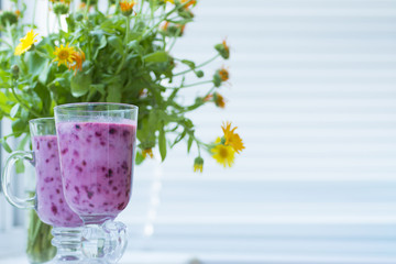 Summer juicy berry smoothie cocktail with mint leaves. Glass of fresh cool berry cocktail and summer sunny mood. Bright and delicious smoothie for a healthy vegan diet and nutrition.