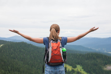 Young woman backpacker at mountain top. Happy and cheering concept