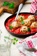 chicken meatballs with tomato sauce in a frying pan. style vintage