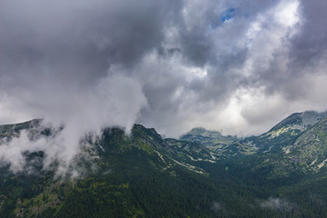 Mountain landscape in the Transylvanian Alps in summer, with mist clouds after the rain