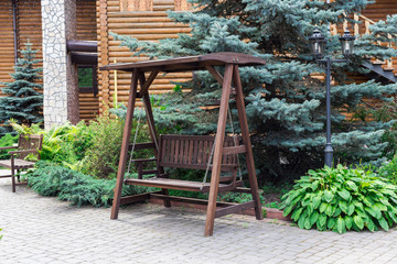 Wooden swing in summer garden