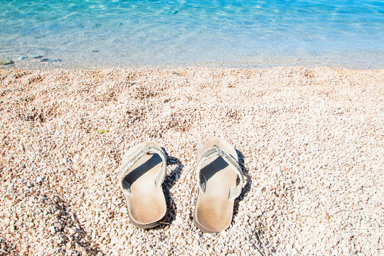 Flip Flop slippers on sandy beach, summertime, Croatia, island of Cres