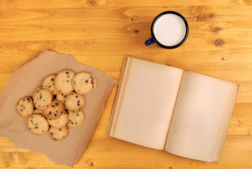 Homemade chocolate chip cookies, milk cup and book