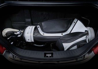 Golf bag and gas tank in car trunk, showing enough space.
