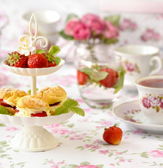 Cream puffs cakes or profiterole filled with whipped cream served with strawberries in plateau