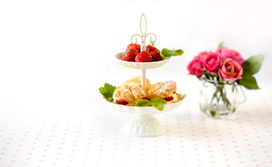 Cream puffs cakes or profiterole filled with whipped cream served with strawberries in plateau