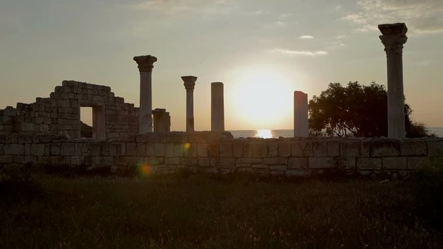 Ancient Greek basilica and marble columns in Chersonesus Taurica on the sunset background.
