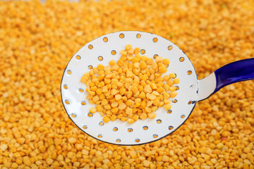 Metallic spoon on split peas background