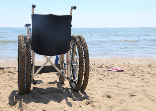 wheelchair on the beach by the sea