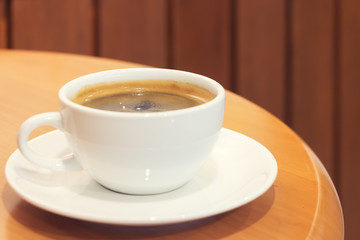 Closeup white cup of coffee on wood table