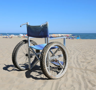 wheelchair on the sand beach near the sea