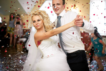 Groom bends gorgeous bride over dancing in the shower of confett