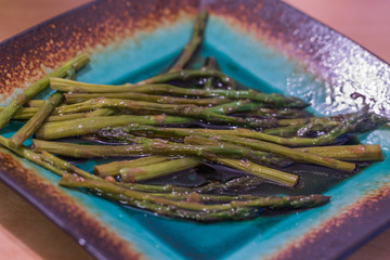 Fried asparagus on turquoise plate.