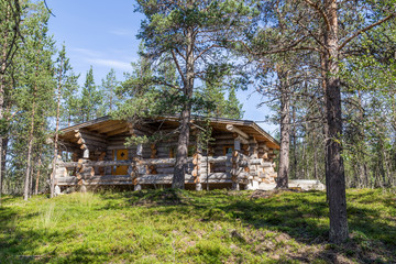 Fototapeta na wymiar Finnish wooden loghouse in the forest of Lapland