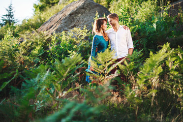 Naklejka na ściany i meble Nice couple embracing among trees and fern