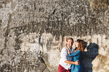 Nice couple standing near stone wall