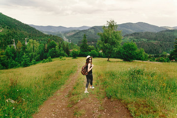 stylish hipster  in hat with backpack walking and smiling on bac