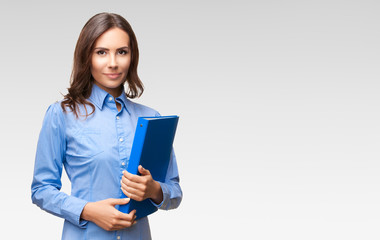 Businesswoman with blue folder, against grey