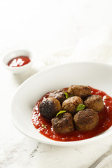 Meatballs with ketchup with tomatoes, chili and peaches