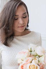 Obraz na płótnie Canvas Pin-up girl in a white dress with flowers
