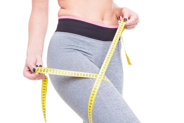 Close-up of woman at gym measuring her thigh