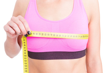 Close-up of fit lady measuring bust line