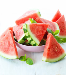 Triangular slices of fresh watermelon on white wooden background