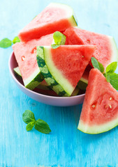 Triangular slices of fresh watermelon on blue wooden background