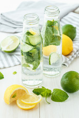 Infused water with citrus and mint in glass bottles