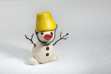 little snowman made of plasticine standing on real snow