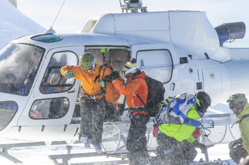 Freerider steigen auf einem Gletscher aus dem Helikopter