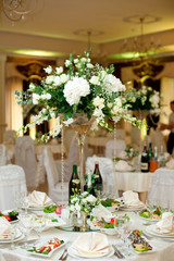 Gorgeous bouquet made of white flowers and greenery stands on wh