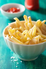 french fries with ketchup over green background