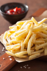 french fries with ketchup over rustic background