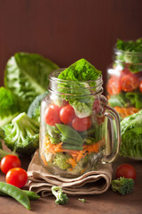 healthy vegetable salad in mason jar. tomato broccoli carrot pea