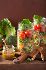 healthy vegetable salad in mason jar. tomato broccoli carrot pea