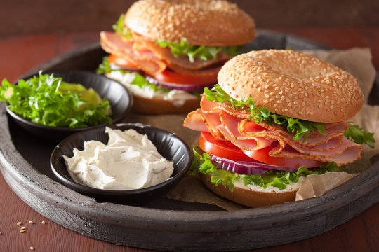ham sandwich on bagel with cream cheese tomato onion