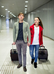 Portrait of young couple with wheeled trollers