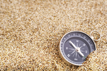 Compass on sand background