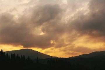 amazing sunset in mountains landscape, sun and clouds and woods